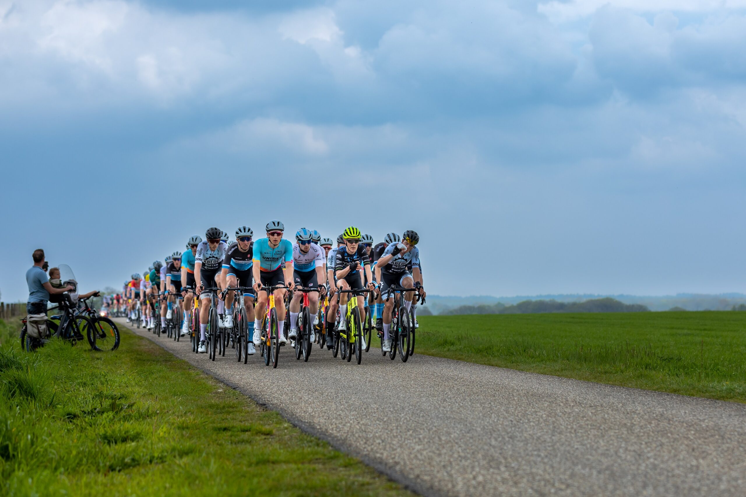 Bijschrift: Het peloton bij Ootmarsum. Op 4 mei krijgen de renners een extra beklimming bij Hoge Hexel. Fotograaf: Herbert Huizer